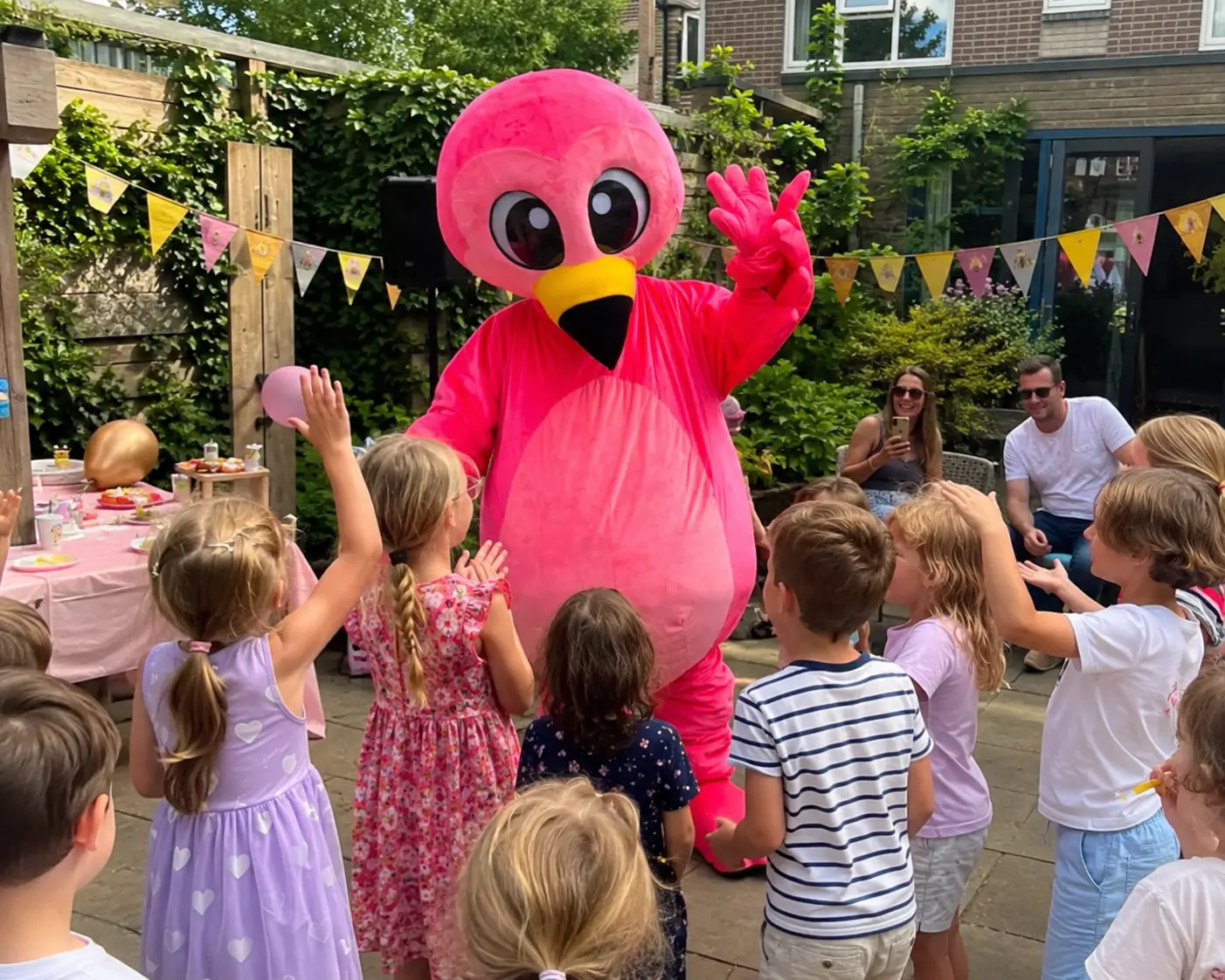Flami zwaait naar een groep kinderen op een buurtfeest in de tuin